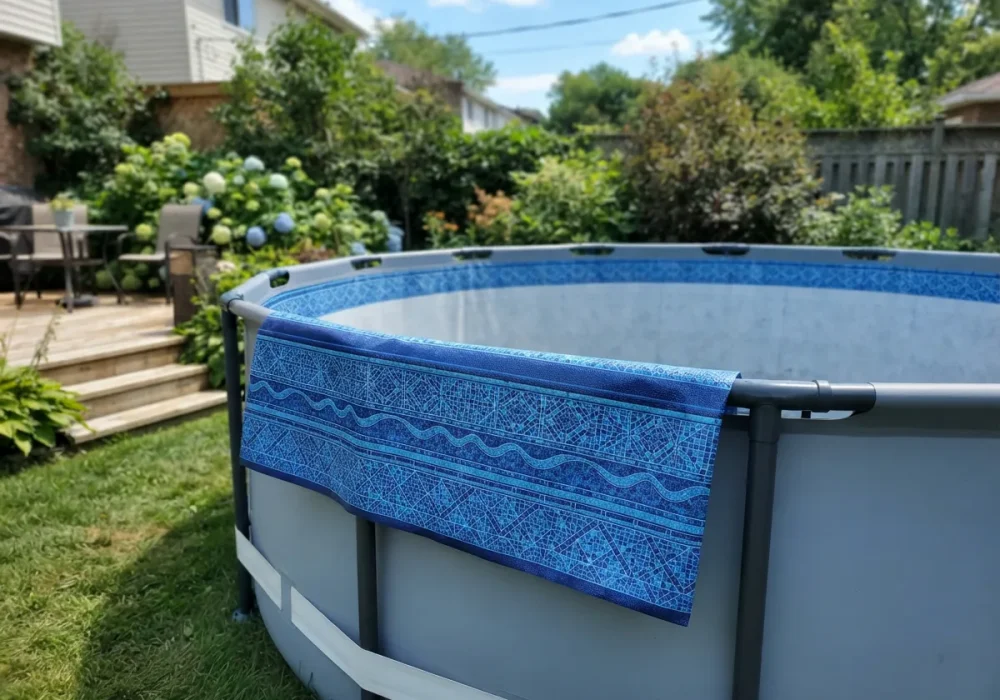 A Summer Waves pool liner with a blue tile pattern displayed on the edge of an empty above-ground pool.